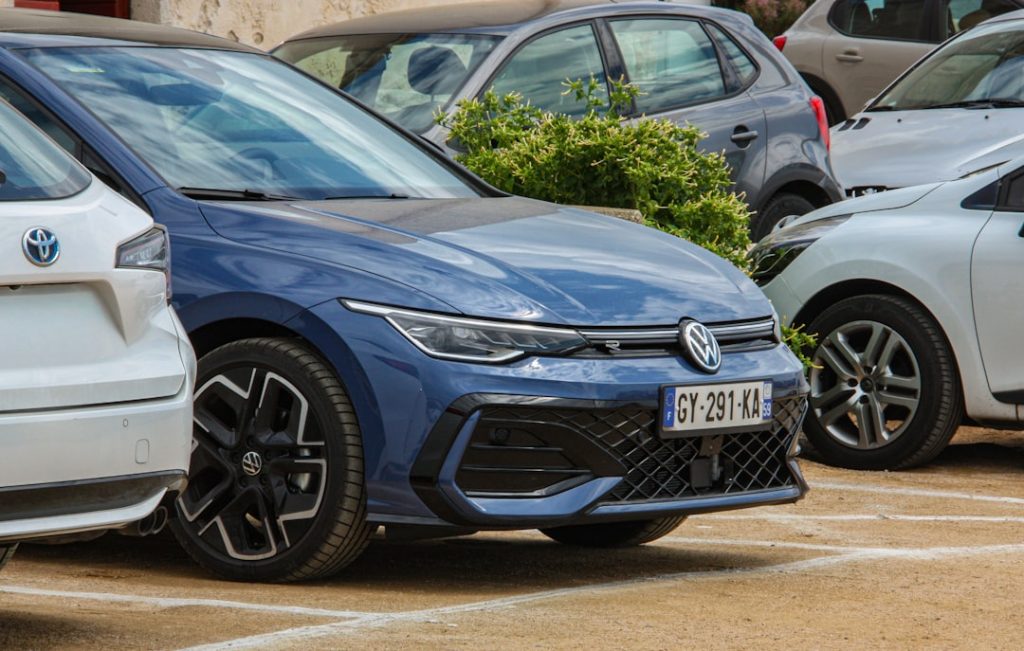 Blue volkswagen golf parked in a lot.