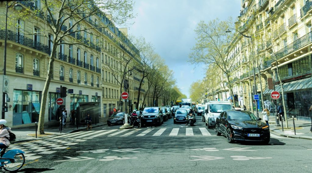 A city street filled with traffic next to tall buildings