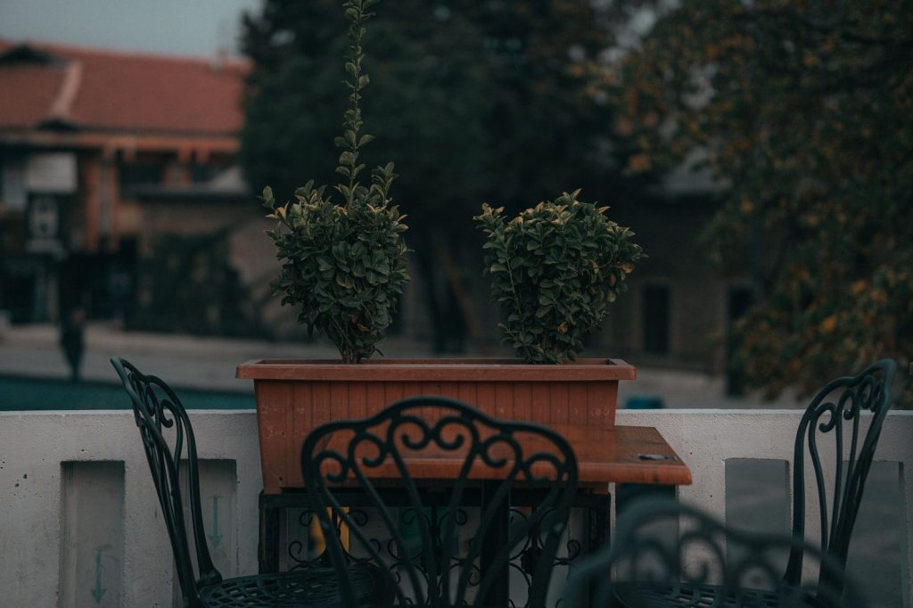 Un salon de jardin en bois exposé aux intempéries sur un balcon.