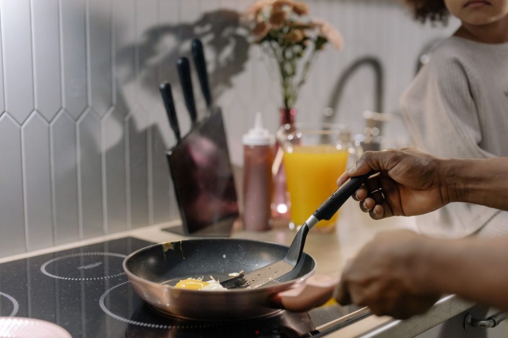Une spatule en bois utilisée sur une poêle antiadhésive.