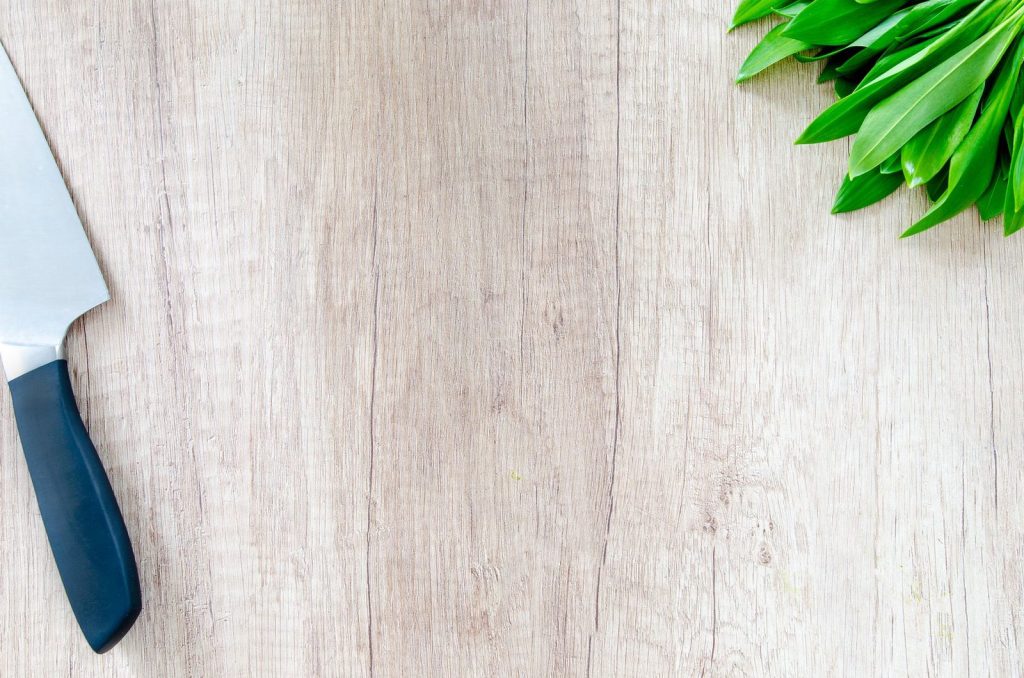 Un couteau de chef bien affûté sur une planche à découper.