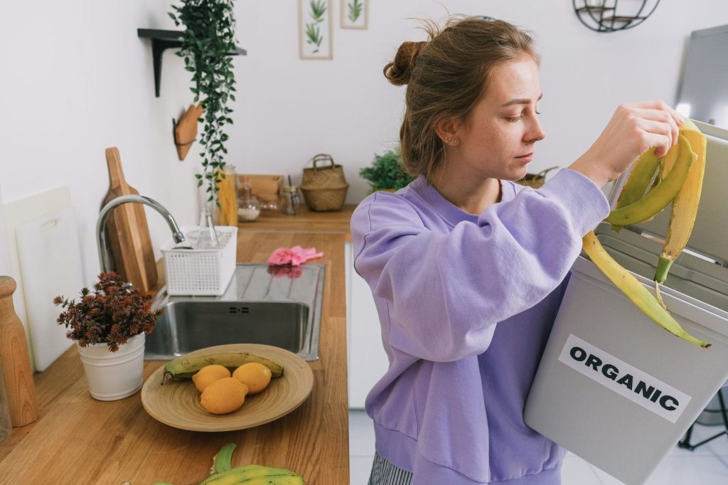 Tri des épluchures dans un bac à compost en cuisine.