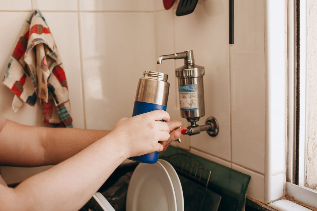 Un filtre à eau fixé sur un robinet de cuisine.