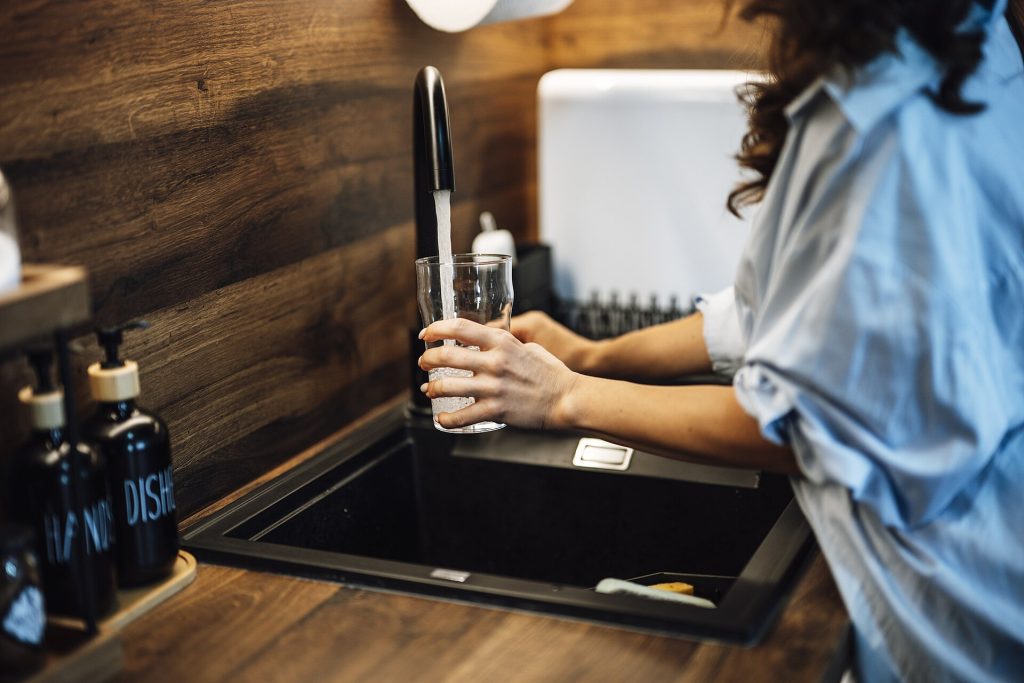 Verre rempli d eau au robinet d une cuisine