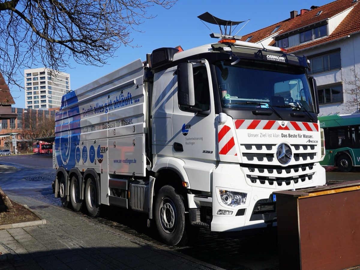 Camion hydrocureur européen stationné dans une rue résidentielle
