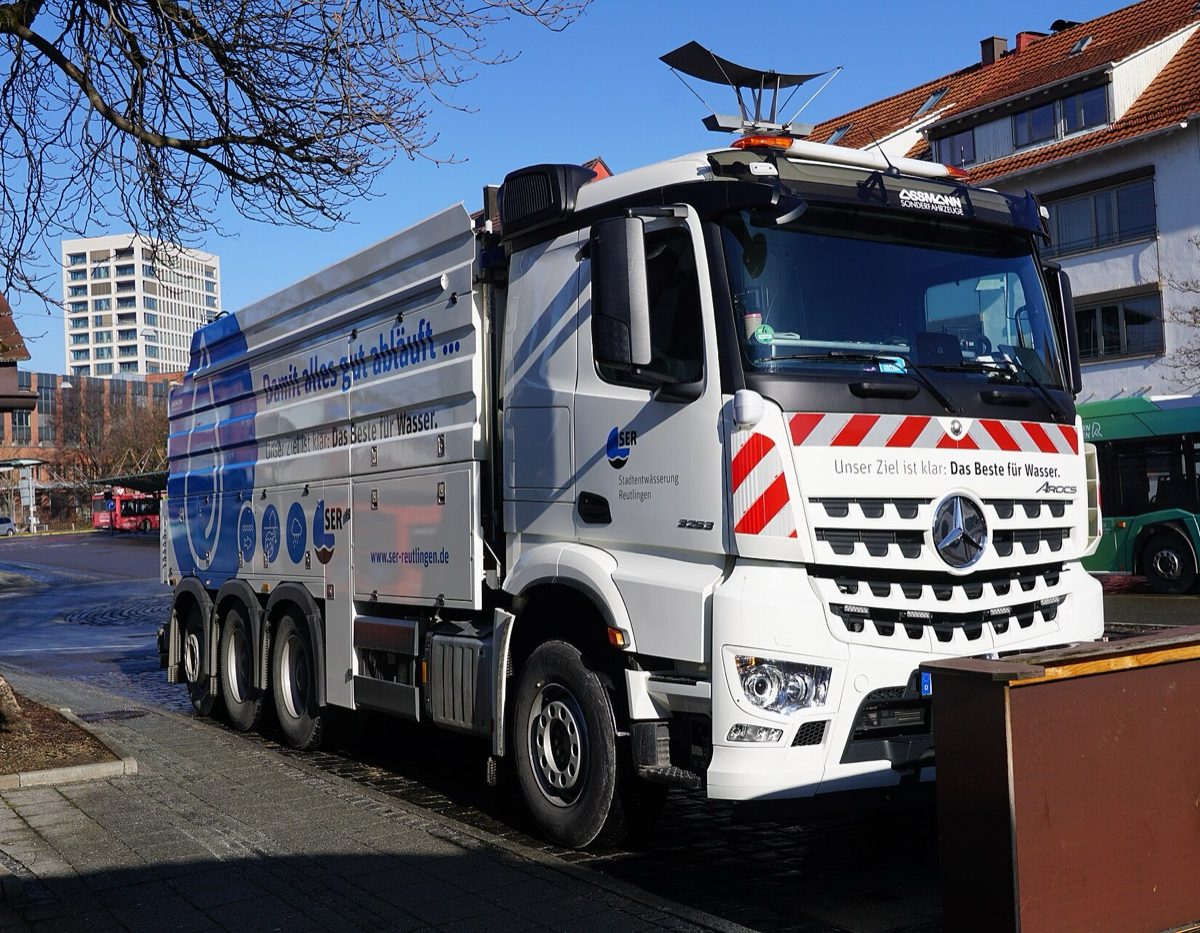 Camion hydrocureur européen stationné dans une rue résidentielle
