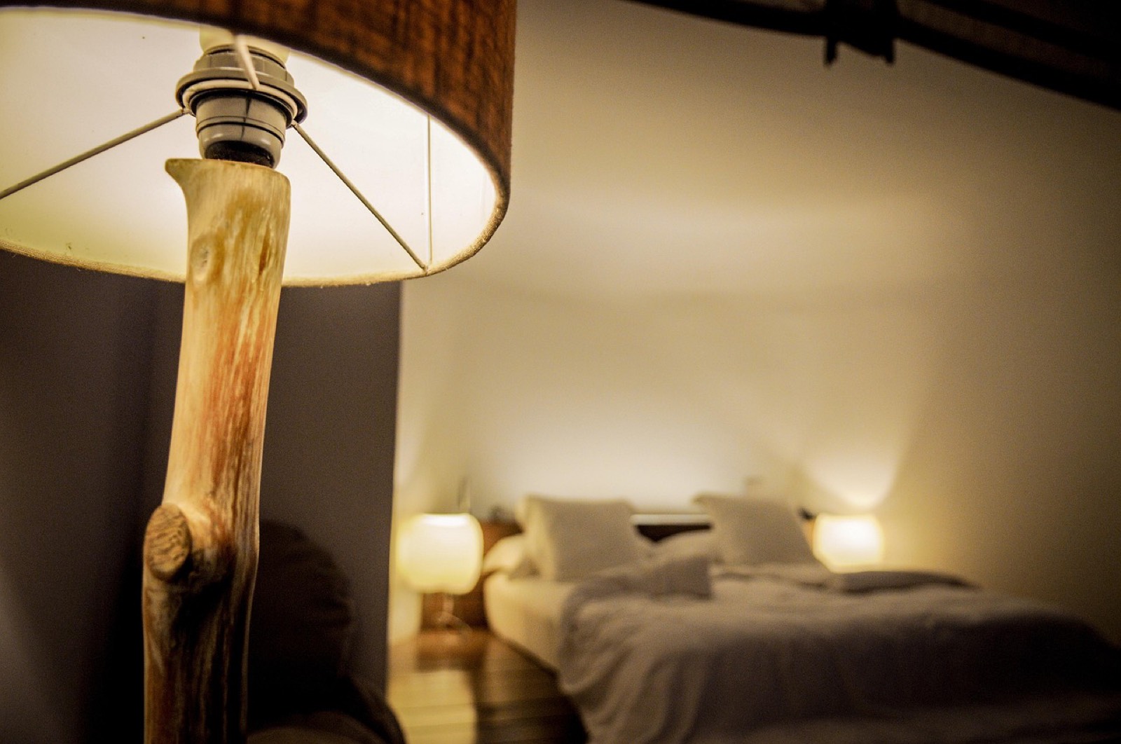 Lampe de chevet allumée diffusant une lumière blanc chaud dans une chambre