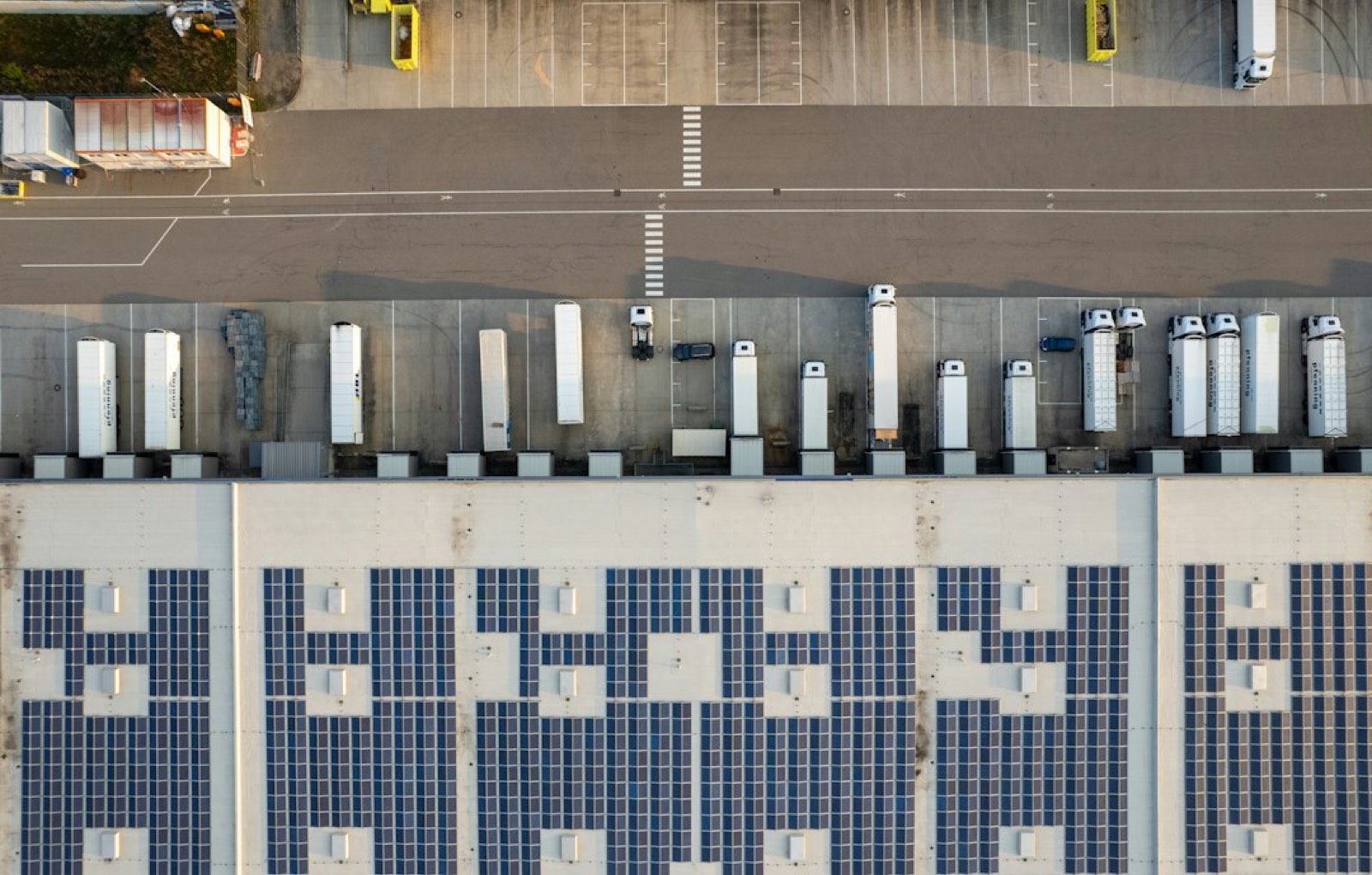 Rangée d'ombrières photovoltaïques qui abritent des voitures sur un parking extérieur