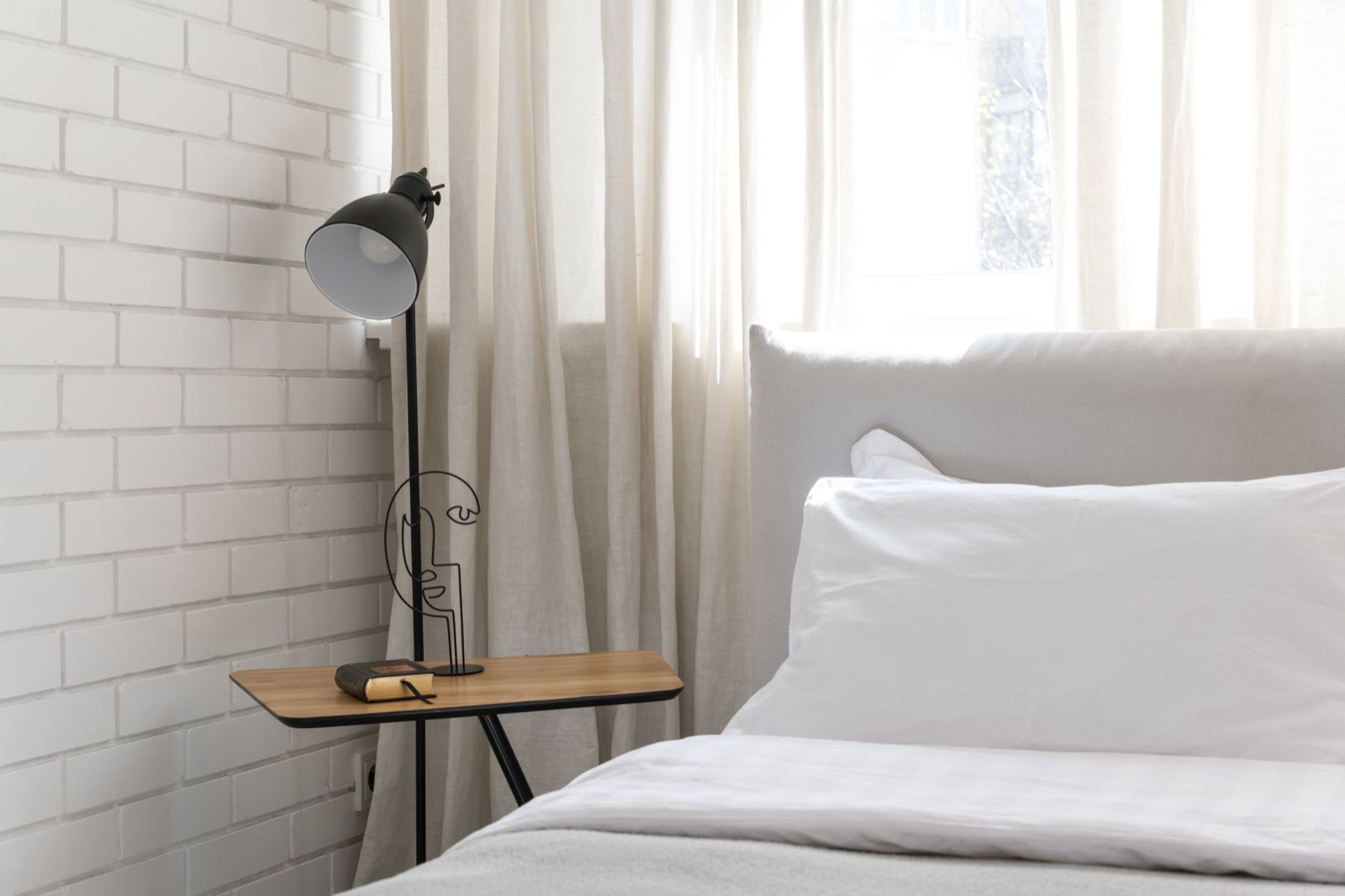 Lampe design en laiton sur une table de chevet